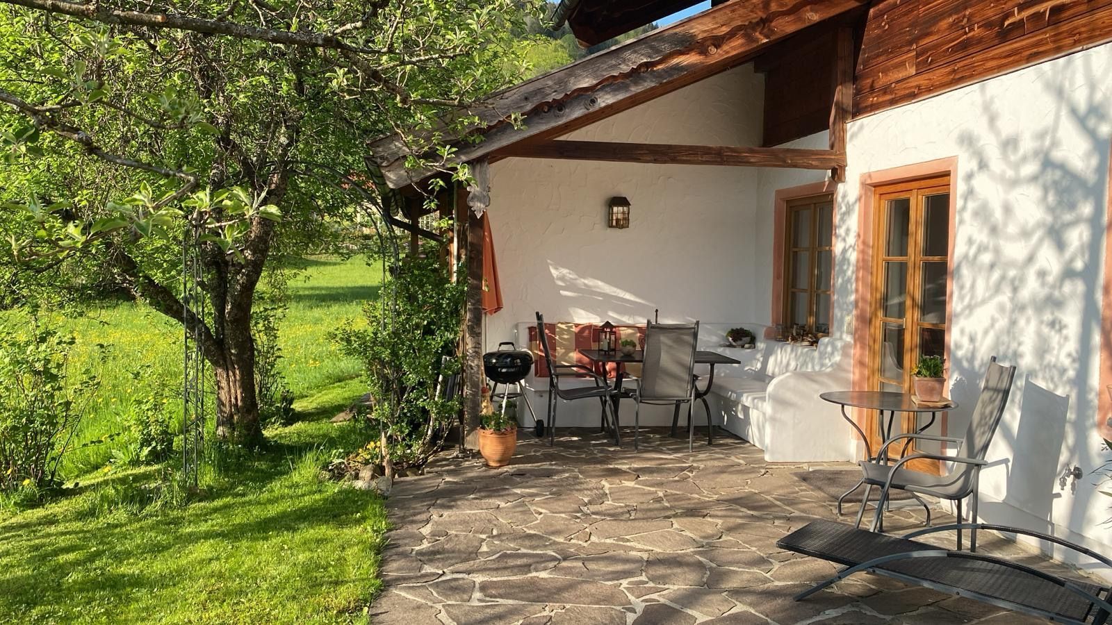 Private Terrasse der Ferienwohnung Sonnengarten mit Sitzplatz, Grill und Blick in den Obstgarten